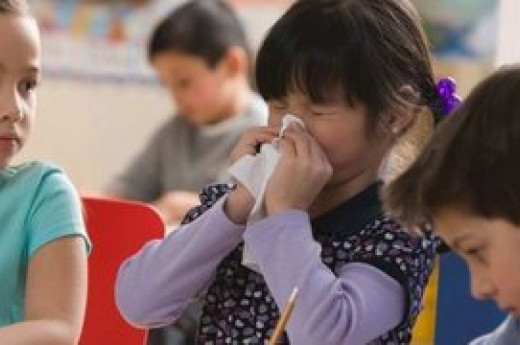 A child sneezing on tissue