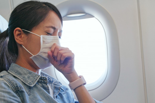 a woman wearing surgical mask in plane
